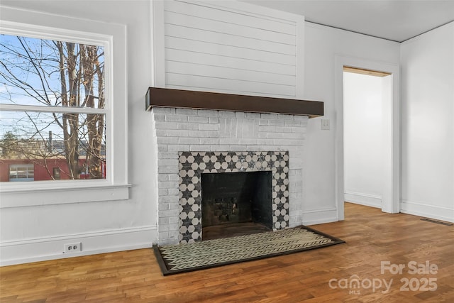 room details with wood-type flooring and a tile fireplace