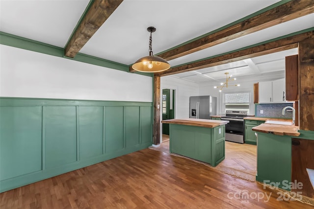 kitchen featuring wood counters, hanging light fixtures, stainless steel appliances, and a center island