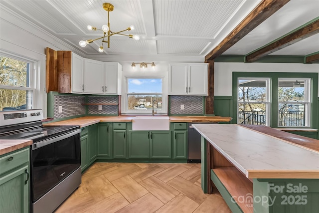 kitchen with sink, appliances with stainless steel finishes, green cabinetry, white cabinets, and decorative light fixtures