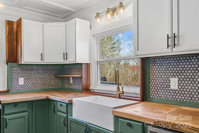 kitchen with butcher block countertops, sink, white cabinets, and green cabinets