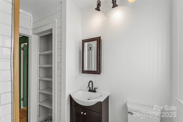 bathroom featuring vanity, built in features, and toilet