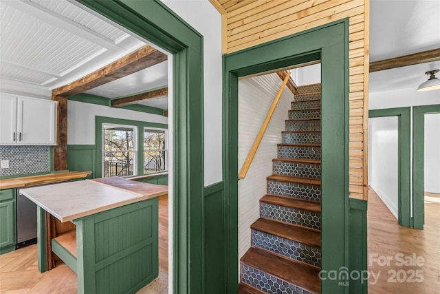 stairway with hardwood / wood-style floors and beamed ceiling