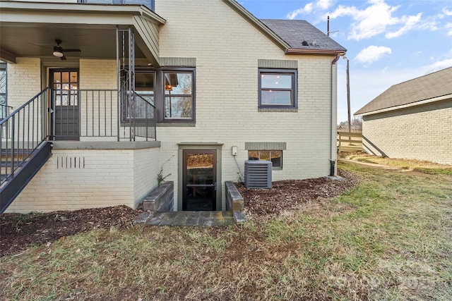 back of property featuring cooling unit, a lawn, and ceiling fan