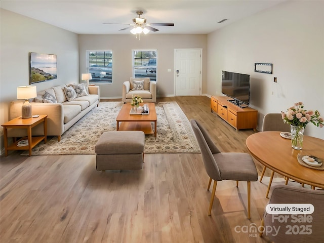 living room with ceiling fan and light wood-type flooring