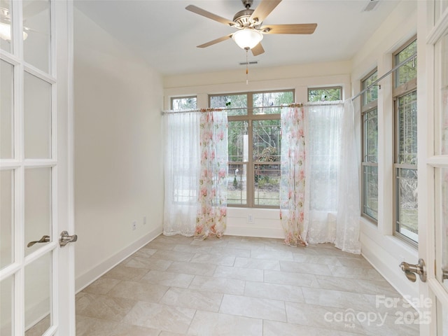 unfurnished sunroom featuring ceiling fan