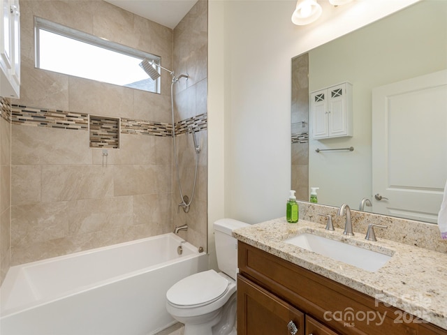 full bathroom featuring tiled shower / bath, vanity, and toilet