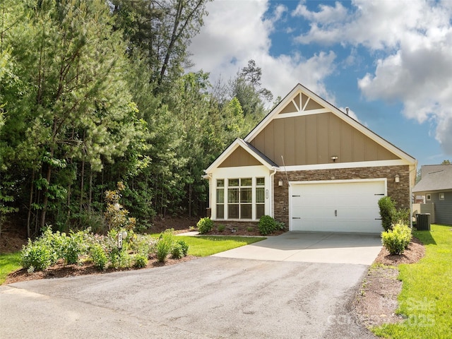 51 Honeycrisp Ct, Flat Rock, NC 28731 - view of front of home featuring stone siding, driveway, central air condition unit, board and batten siding, and an attached garage