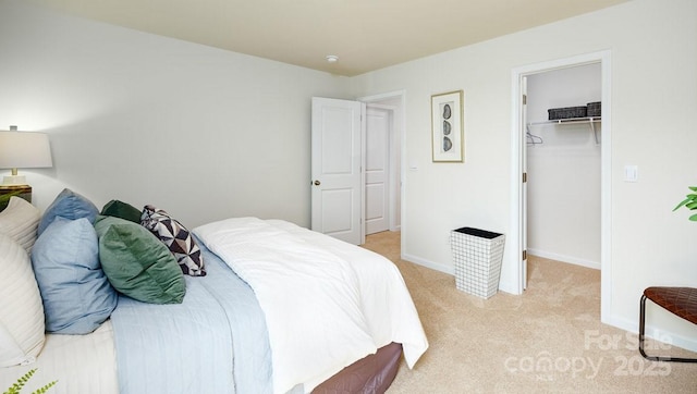 carpeted bedroom with a spacious closet and a closet