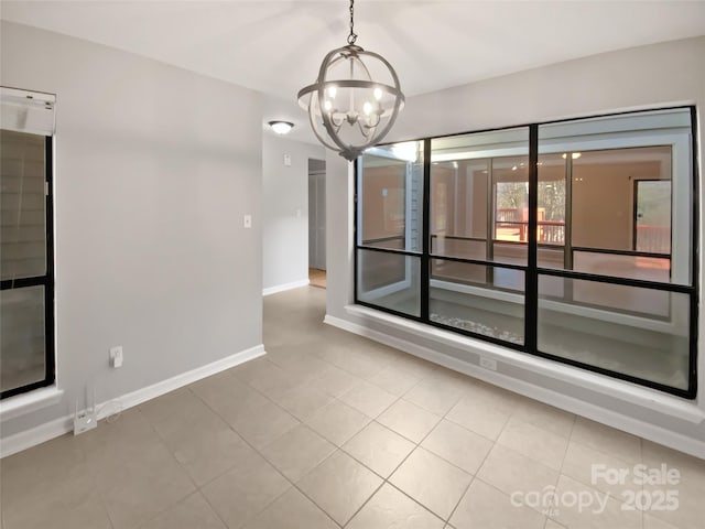 spare room with light tile patterned floors and a chandelier