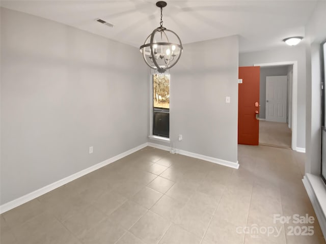 tiled empty room featuring a notable chandelier