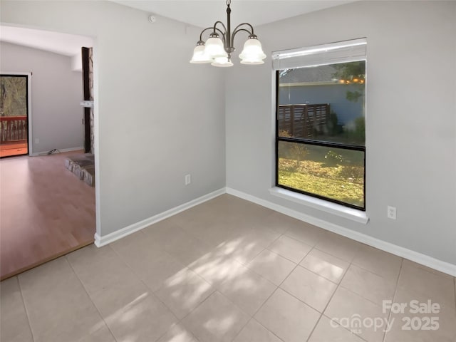 unfurnished dining area with a chandelier and light tile patterned floors