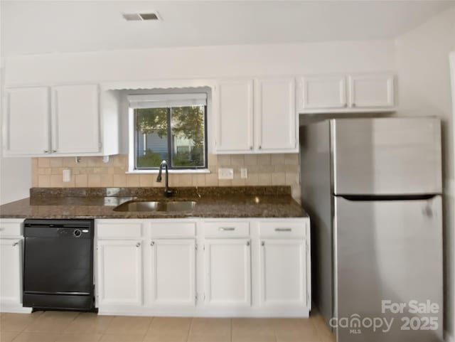 kitchen featuring stainless steel fridge, dishwasher, sink, and dark stone countertops