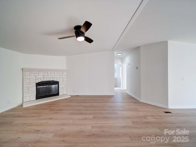 unfurnished living room featuring ceiling fan, a fireplace, and light hardwood / wood-style floors