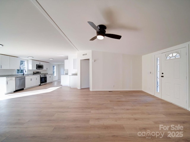 unfurnished living room with light hardwood / wood-style floors and ceiling fan