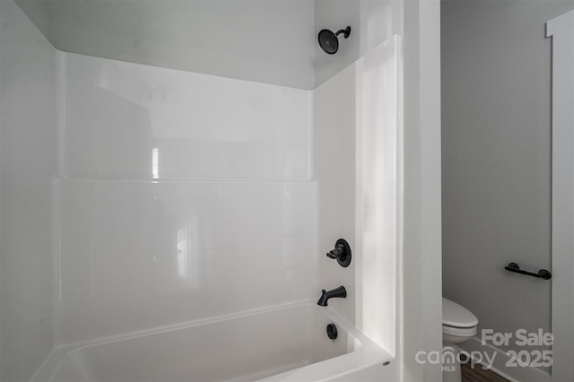 bathroom featuring toilet and washtub / shower combination