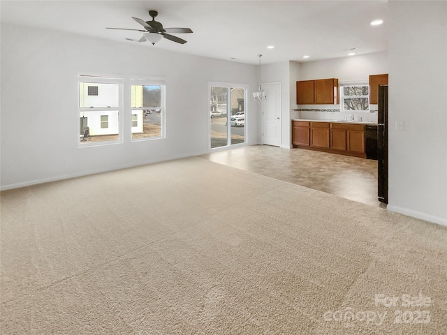 unfurnished living room featuring light colored carpet and ceiling fan