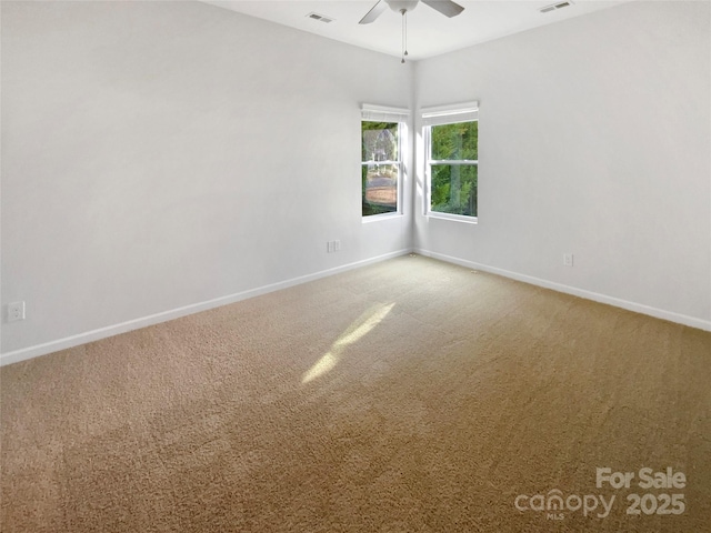 carpeted spare room with ceiling fan