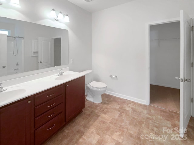 bathroom with vanity, walk in shower, and toilet