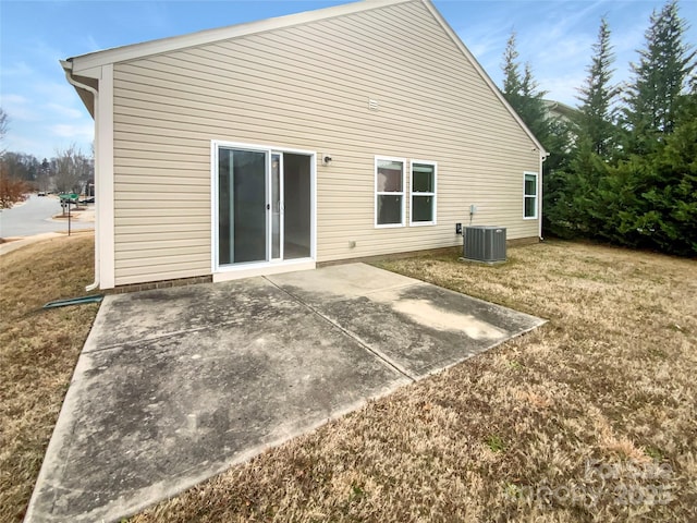 back of property with a lawn, cooling unit, and a patio area