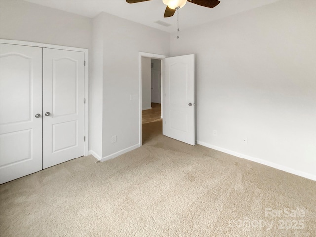 unfurnished bedroom featuring light colored carpet, ceiling fan, and a closet