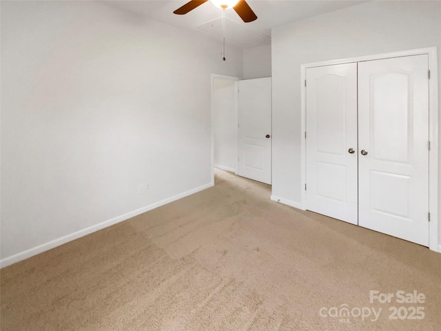 unfurnished bedroom featuring light colored carpet, ceiling fan, and a closet