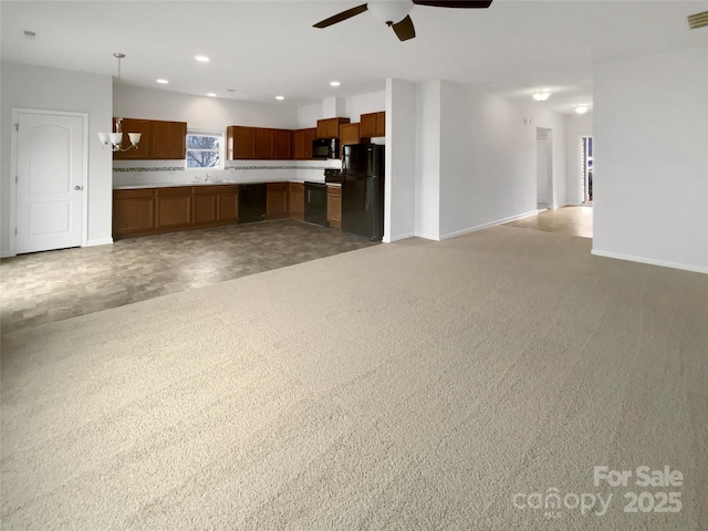 unfurnished living room with carpet and ceiling fan with notable chandelier