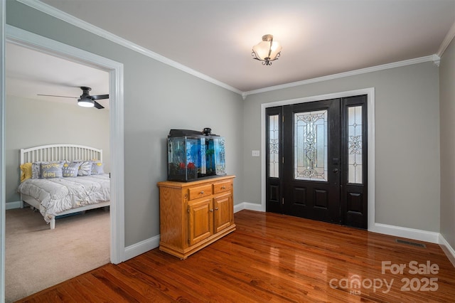 entryway featuring ceiling fan, ornamental molding, and wood-type flooring