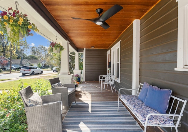 wooden terrace with covered porch and a ceiling fan