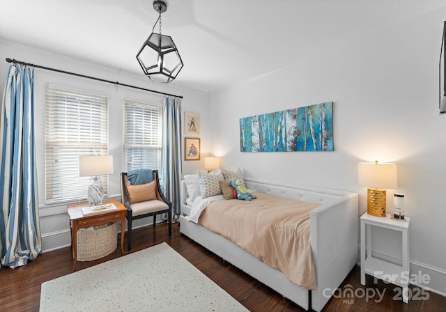 bedroom with dark wood-type flooring and baseboards