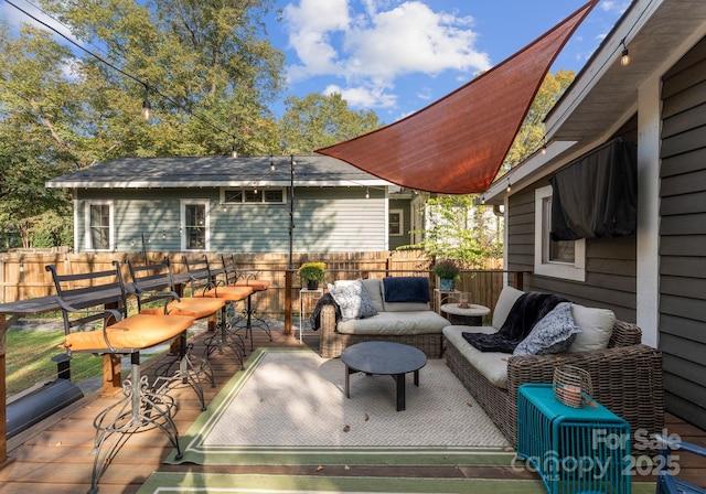 deck featuring exterior bar, fence, and an outdoor living space