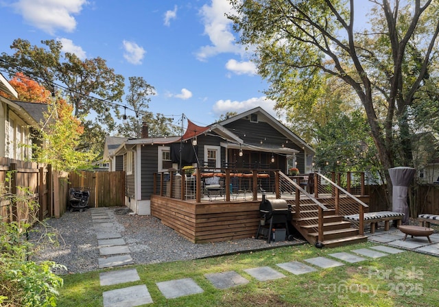 back of property with a fenced backyard and a deck