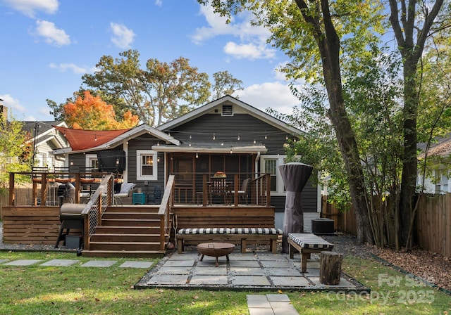 rear view of house featuring a patio, a sunroom, stairway, fence, and a deck