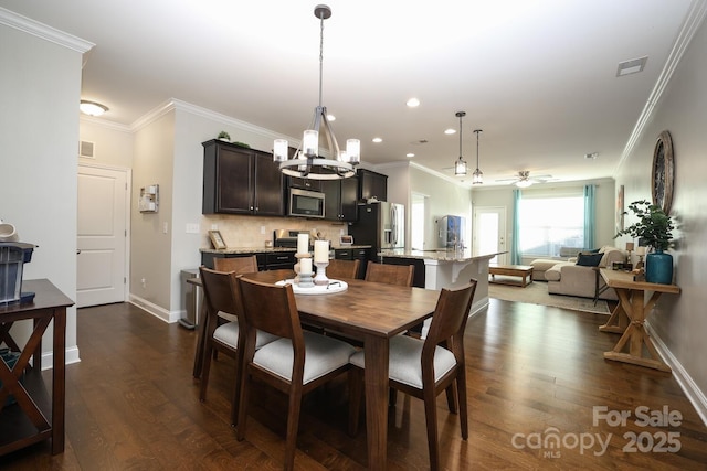 dining space featuring crown molding, ceiling fan with notable chandelier, and dark hardwood / wood-style flooring