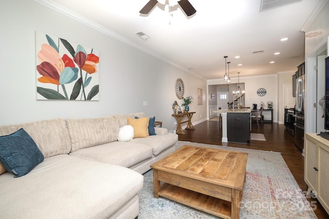 living room featuring ornamental molding, dark hardwood / wood-style floors, and ceiling fan with notable chandelier