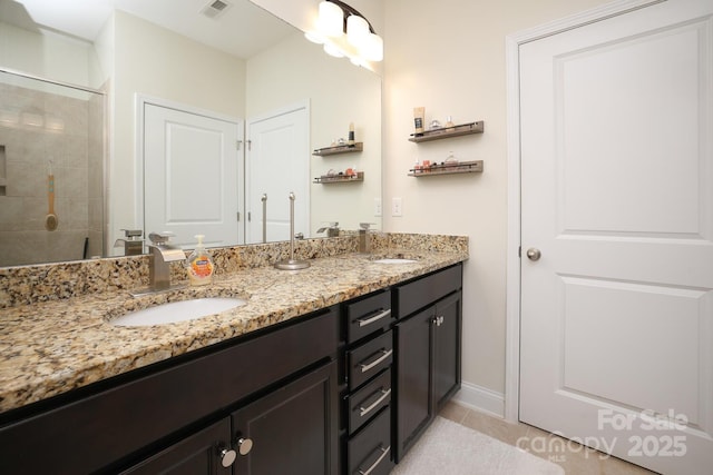 bathroom with vanity, tile patterned flooring, and a tile shower