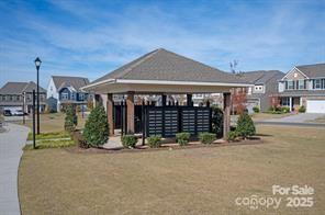 surrounding community featuring a gazebo, mail boxes, and a lawn