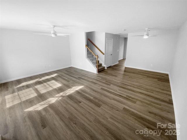 unfurnished living room with dark hardwood / wood-style flooring and ceiling fan