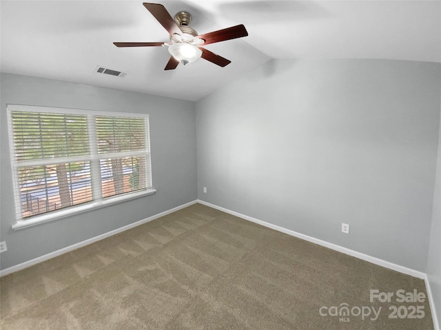 carpeted spare room featuring ceiling fan and lofted ceiling