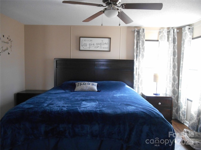 bedroom featuring a textured ceiling, wood-type flooring, and ceiling fan