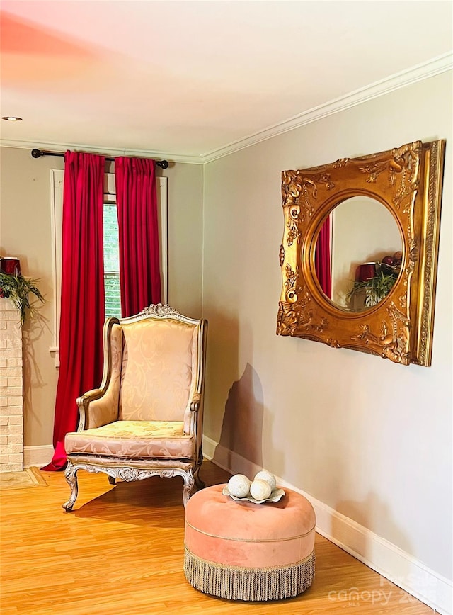 sitting room with crown molding and hardwood / wood-style flooring