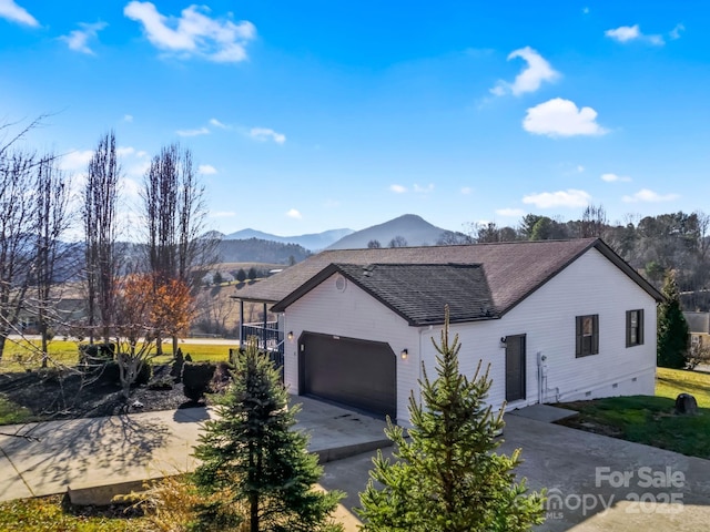 view of front of home with a mountain view and a garage