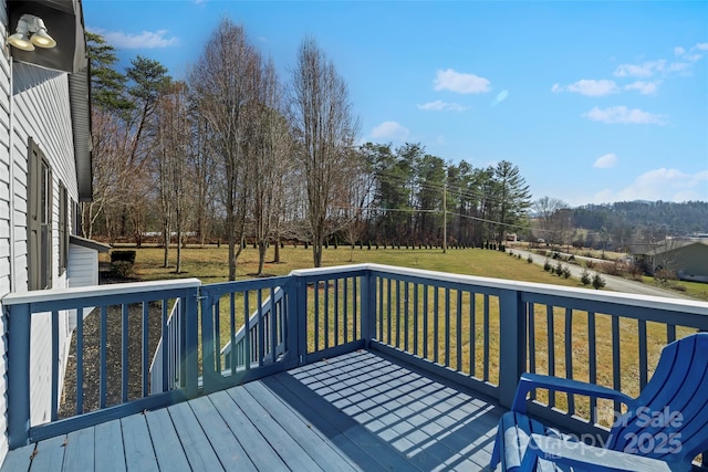 wooden deck featuring a lawn