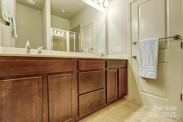 bathroom featuring walk in shower, vanity, and tile patterned flooring