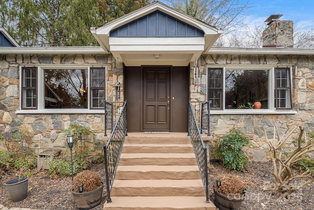 property entrance with stone siding and board and batten siding