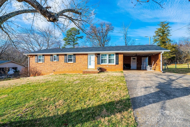 ranch-style home with driveway, brick siding, a carport, and a front yard