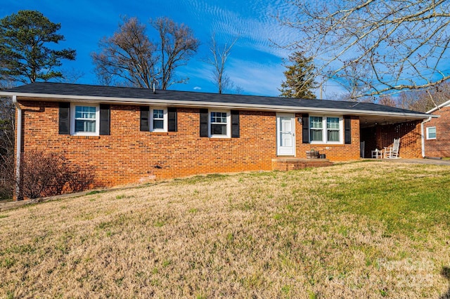 ranch-style house featuring roof with shingles, a front lawn, and brick siding