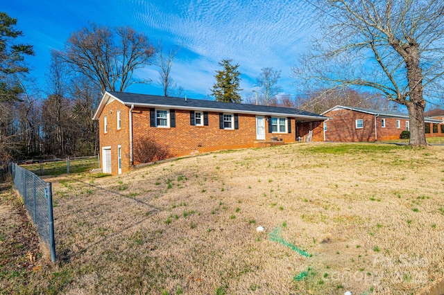 ranch-style house with a garage, brick siding, a front yard, and fence