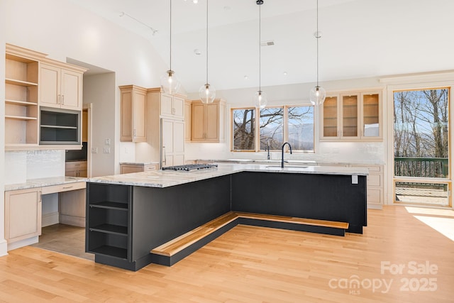 kitchen featuring pendant lighting, light hardwood / wood-style floors, a center island, and a kitchen bar