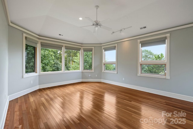 empty room featuring wood-type flooring, rail lighting, and ceiling fan