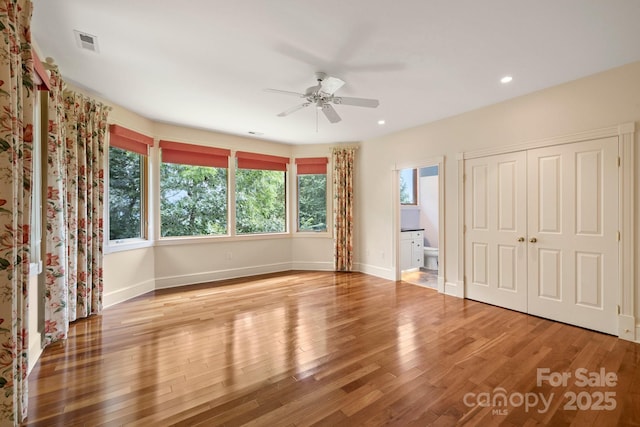 interior space featuring ensuite bath, a closet, ceiling fan, and light wood-type flooring